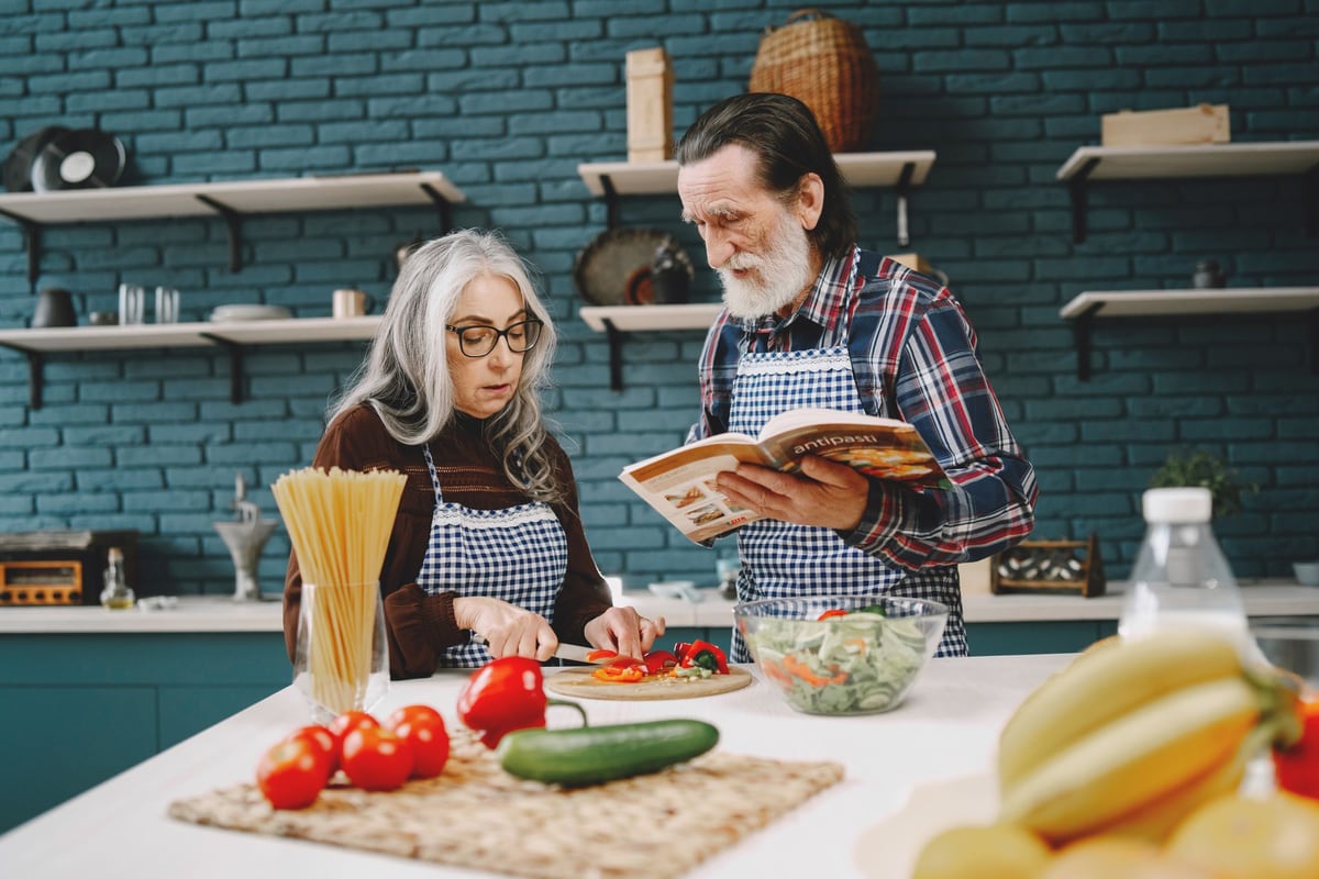 Älteres Paar bereitet gemeinsam eine Mahlzeit zu